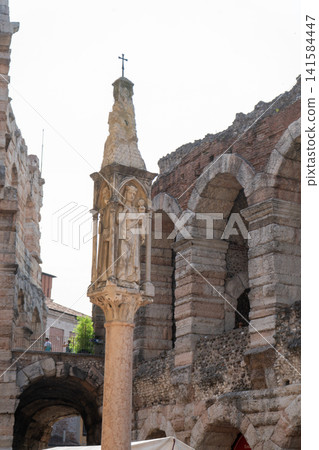 Gothic Statue Column of Madonna and Child in Front of Stone Arches of Arena di Verona in Italy Gothic Statue Column of Madonna and Child in Front of Stone Arches of Arena di Verona in Italy 141584447
