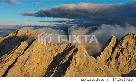 Amazing rocky mountains in clouds at sunset Amazing rocky mountains in clouds at sunset 141585729