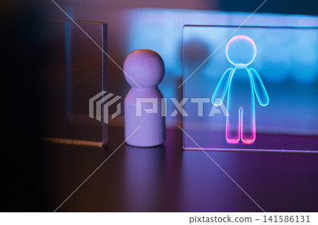 Wooden figure beside illuminated acrylic panel displaying glowing human outline, with soft blue and pink lighting creating a modern, abstract atmosphere Wooden figure beside illuminated acrylic panel displaying glowing human outline, with soft blue and pink lighting creating a modern, abstract atmosphere 141586131