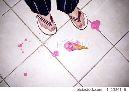 Person wearing flip-flops stands on tiled floor with spilled pink ice cream and a fallen cone, creating a messy scene in a domestic setting Person wearing flip-flops stands on tiled floor with spilled pink ice cream and a fallen cone, creating a messy scene in a domestic setting 141586146