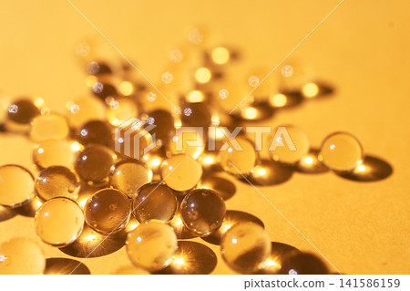 Transparent water droplets scattered on a golden surface, reflecting light and creating soft shadows, showcasing a unique texture and visual appeal Transparent water droplets scattered on a golden surface, reflecting light and creating soft shadows, showcasing a unique texture and visual appeal 141586159