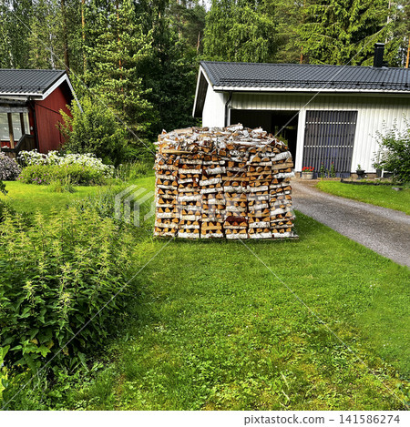 Woodpile of Birch Firewood on Lawn in Porvoo, Finland. Woodpile of Birch Firewood on Lawn in Porvoo, Finland. 141586274