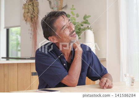 A man experiencing pain from his neck to his shoulder. 141586284