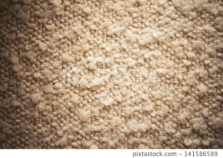 Close-up view of textured beige fabric with small raised fibers creating a soft, tactile surface suitable for upholstery or interior design applications Close-up view of textured beige fabric with small raised fibers creating a soft, tactile surface suitable for upholstery or interior design applications 141586589