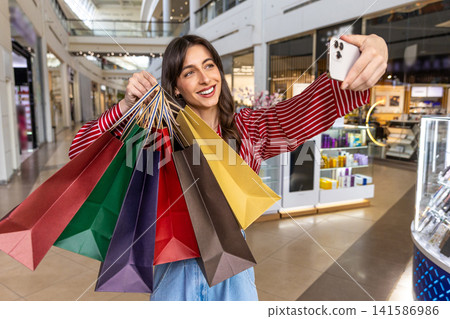 Pretty young woman making selfie in a shopping mall Pretty young woman making selfie in a shopping mall 141586986