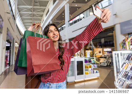 Pretty young woman making selfie in a shopping mall Pretty young woman making selfie in a shopping mall 141586987