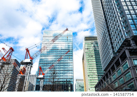 Large cranes and skyscrapers at a construction site Large cranes and skyscrapers at a construction site 141587754