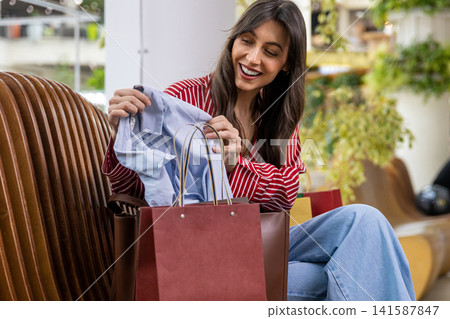Pretty young woman resting after shopping and feeling good and positive Pretty young woman resting after shopping and feeling good and positive 141587847