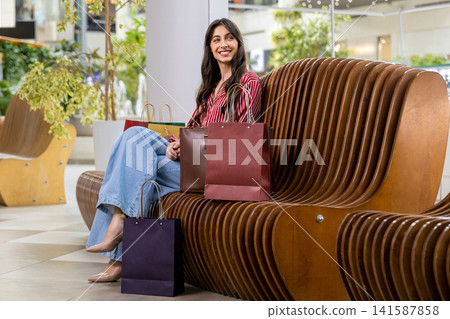 Pretty young woman resting after shopping and feeling good and positive Pretty young woman resting after shopping and feeling good and positive 141587858