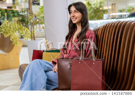 Pretty young woman resting after shopping and feeling good and positive Pretty young woman resting after shopping and feeling good and positive 141587860