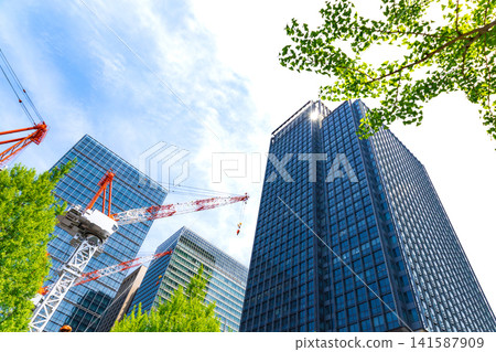 Large cranes and skyscrapers at a construction site Large cranes and skyscrapers at a construction site 141587909