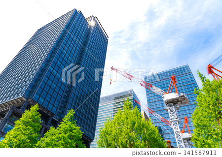 Large cranes and skyscrapers at a construction site Large cranes and skyscrapers at a construction site 141587911