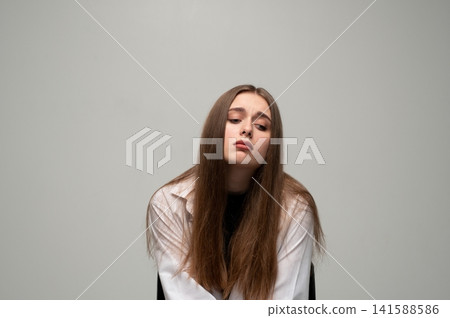 Young woman feeling sad and tired, showing depression, loneliness, or mental health issues, with a melancholic expression Young woman feeling sad and tired, showing depression, loneliness, or mental health issues, with a melancholic expression 141588586