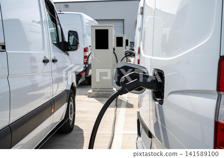 Fleet of electric vans charging at a modern charging station outdoors Fleet of electric vans charging at a modern charging station outdoors 141589100