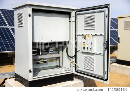 Outdoor electrical control cabinet with solar panels in the background Outdoor electrical control cabinet with solar panels in the background 141589184