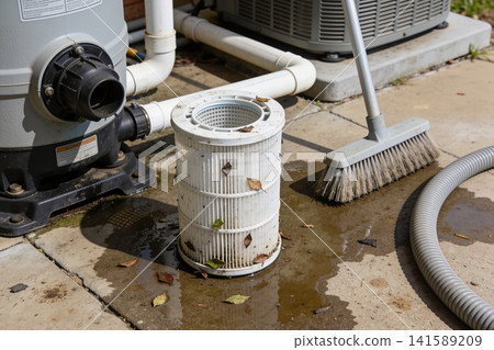 Pool filter cleaning supplies and equipment on a wet patio Pool filter cleaning supplies and equipment on a wet patio 141589209