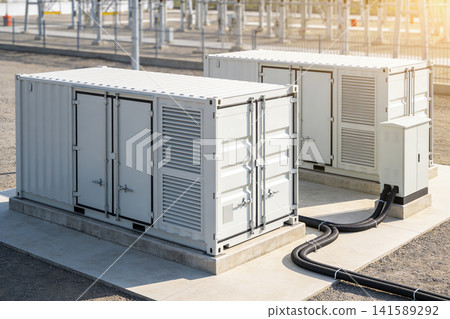 Modern energy storage containers at a substation with electrical infrastructure in background Modern energy storage containers at a substation with electrical infrastructure in background 141589292