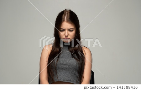 Young woman feeling sad and unhappy, pouting with a worried expression, dealing with emotions of disappointment 141589416