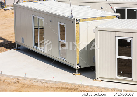 Modular construction units being assembled on a concrete foundation at a building site Modular construction units being assembled on a concrete foundation at a building site 141590108