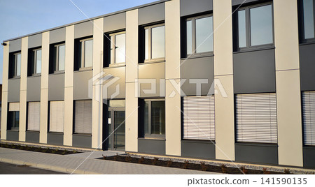 Modern office building facade with large windows and vertical paneling Modern office building facade with large windows and vertical paneling 141590135