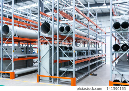 Industrial warehouse interior with large pipes stored on metal shelving units Industrial warehouse interior with large pipes stored on metal shelving units 141590163