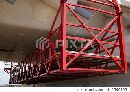 Red metal scaffolding structure attached to a concrete bridge underside Red metal scaffolding structure attached to a concrete bridge underside 141590195