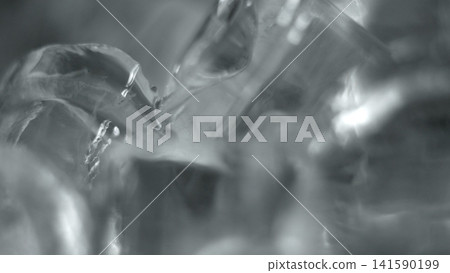 Melting ice texture close-up creating abstract background with liquid drops and frozen cracks Melting ice texture close-up creating abstract background with liquid drops and frozen cracks 141590199