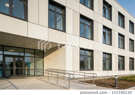 Modern building facade with glass entrance and accessible ramp Modern building facade with glass entrance and accessible ramp 141590230