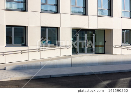 Modern building entrance with glass doors and accessible ramp Modern building entrance with glass doors and accessible ramp 141590260