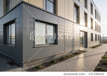 Modern office building exterior with sleek metal facade and large windows Modern office building exterior with sleek metal facade and large windows 141590282