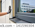 Construction worker installing insulation panels on a modern building exterior 141590304