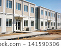 Modern modular building exterior with clean lines and large windows under blue sky 141590306