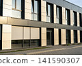 Modern office building facade with large windows and beige paneling 141590307