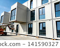 Modular building construction with stacked shipping containers and a crane 141590327