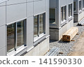 Modern building under construction with concrete foundation and metal siding 141590330
