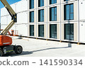 Modern modular building construction with a boom lift and stacked containers 141590334