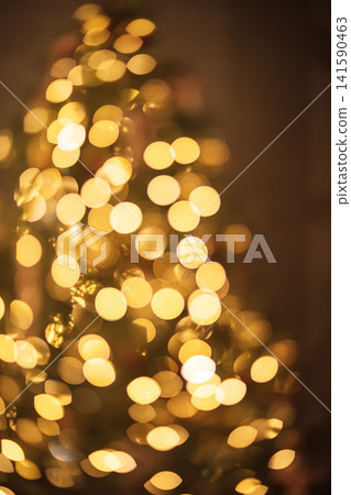 Softly blurred golden bokeh lights create a warm, festive atmosphere, reminiscent of holiday celebrations, enhancing the beauty of seasonal decorations and joyful moments 141590463