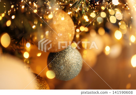 Close-up of gold and silver balls on the Christmas tree. New year card or background. Close-up of gold and silver balls on the Christmas tree. New year card or background. 141590608