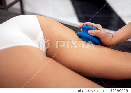 Faceless masseur rubbing back of customer with help of rubber vacuum cup working in salon Faceless masseur rubbing back of customer with help of rubber vacuum cup working in salon 141590609