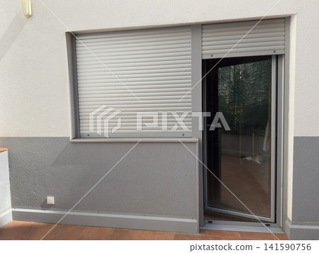 Window with roller shutter and open door on a modern terrace Window with roller shutter and open door on a modern terrace 141590756