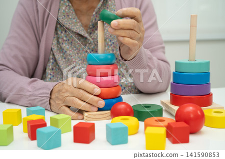 Asian elderly woman patient suffering from dementia learn practical motor skills rehabilitation. Asian elderly woman patient suffering from dementia learn practical motor skills rehabilitation. 141590853