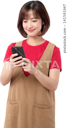 Happy asian woman smiles while engaging with mobile phone. She enjoys modern technology with joyful expression Happy asian woman smiles while engaging with mobile phone. She enjoys modern technology with joyful expression 141591947