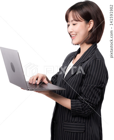 Asian woman professional standing, happily smiling, working on laptop. Focused on business tasks for efficiency Asian woman professional standing, happily smiling, working on laptop. Focused on business tasks for efficiency 141591982