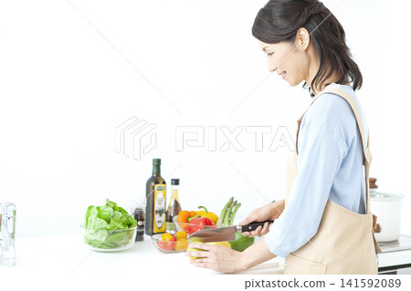 A housewife in an apron cooking A housewife in an apron cooking 141592089