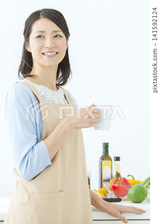 A housewife in an apron holding a teacup A housewife in an apron holding a teacup 141592124