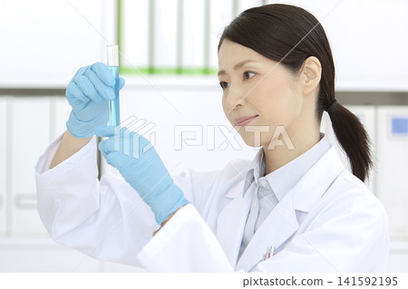 一位身穿白大褂的女子手持試管 141592195