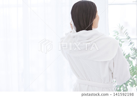 A woman in a bathrobe, seen from behind. A woman in a bathrobe, seen from behind. 141592198