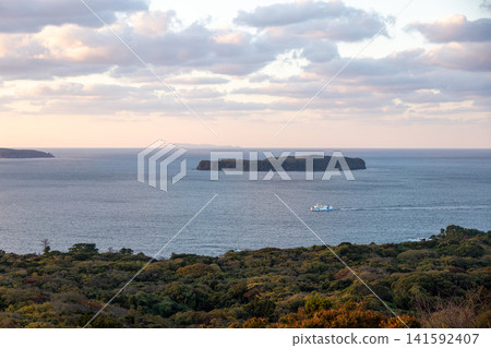 A ship sails across a calm sea, viewed from a sky filled with evening clouds. 141592407