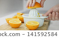Hands extracting fresh orange juice for a healthy beverage 141592584