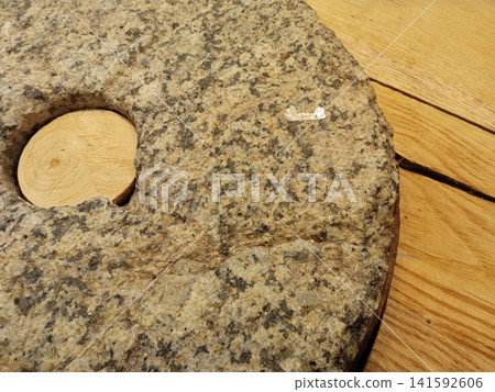 Large stone millstone with a wooden insert on a heated floor Large stone millstone with a wooden insert on a heated floor 141592606